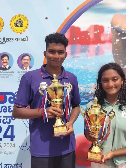 Manikanta L retaining the championship trophy at the Dasara swimming championship.