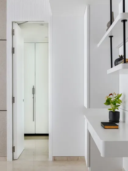 A wider shot showing the hidden door and the minimalist workspace, highlighting the seamless integration of style and convenience.