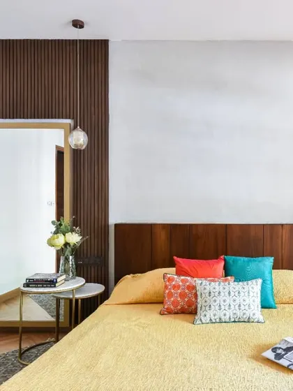 From one of my first interior projects, this bedroom features a stucco accent wall and a fluted wood panel behind a full-length mirror. The herringbone patterned wooden flooring adds a layer of texture and sophistication to the room.