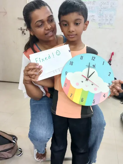 Fixed! A mother and son duo celebrate their repaired wall clock. Our workshops are a great way for families to learn and accomplish something together.