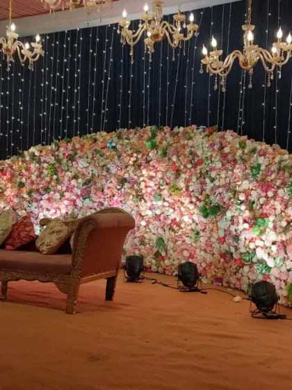 We designed this stage with a massive wall of pastel-colored flowers as the backdrop. The setup is accented with a black fairy light curtain and crystal chandeliers, providing a beautiful contrast and a touch of glamour.