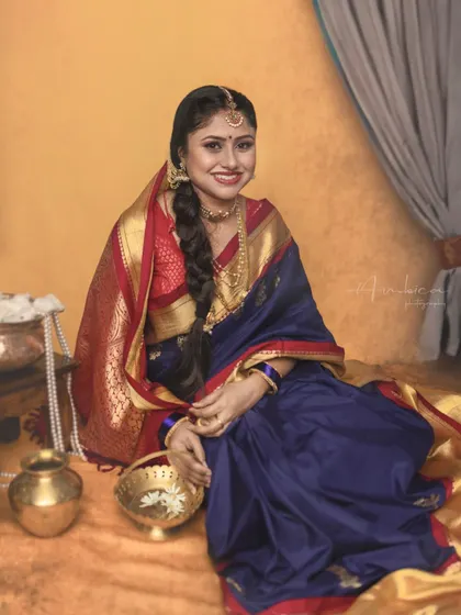 A stunning solo portrait of the mother from a Krishna-themed session. Dressed as Yashoda in a beautiful blue and red saree, she embodies grace and elegance.