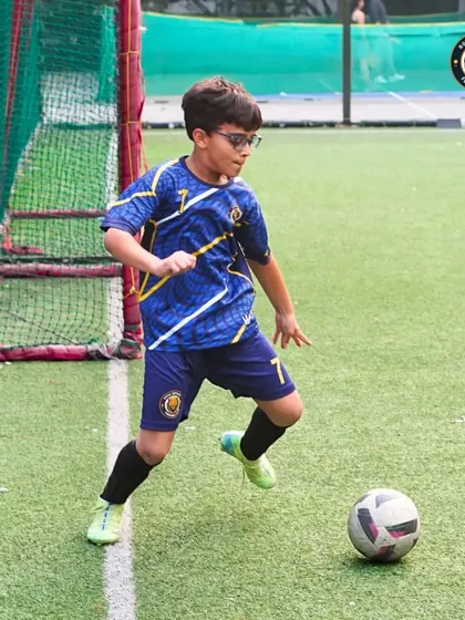 A young midfielder scans the field, ball at his feet, looking for the best option. This demonstrates the game awareness and decision-making skills we cultivate.