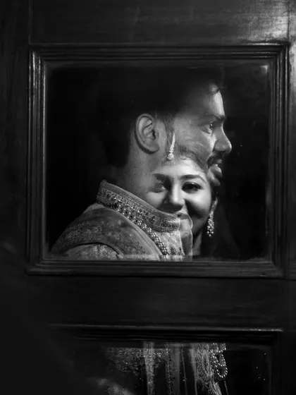 A moody and artistic black and white reflection shot, capturing the couple's profiles in a unique composition.