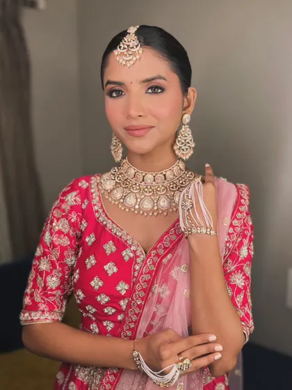 A classic bridal portrait. The makeup is clean and sophisticated, with a focus on flawless skin and beautifully defined eyes, paired with a traditional sleek bun for a timeless look.