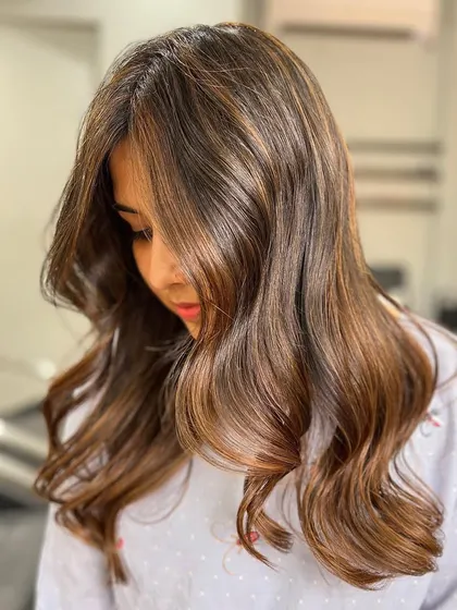 A beautiful caramel blonde balayage, expertly blended for a subtle and seamless effect. This is perfect for a natural, low-maintenance look.