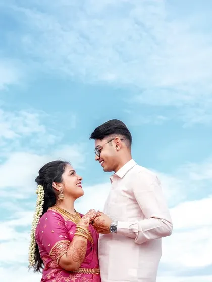 A romantic shot of the couple against a bright blue sky, creating a fresh and happy portrait.