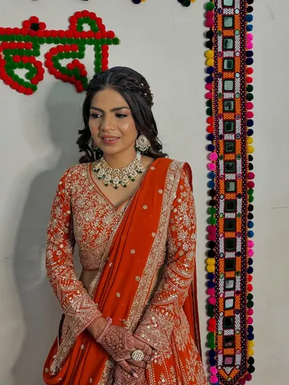 My beautiful bride Maya, ready for her engagement. Her orange lehenga is paired with a stunning diamond and emerald necklace and soft, glowing makeup.