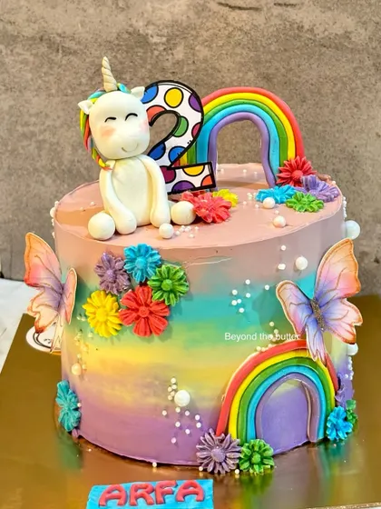 A magical unicorn and rainbow cake for a second birthday. I used a vibrant rainbow color palette for the buttercream and decorations, and topped it with a sweet, handcrafted unicorn.