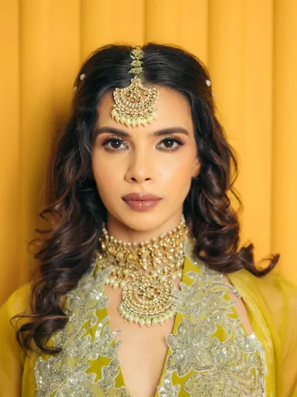 A direct and confident portrait. The makeup is flawless and defined, with a focus on the eyes and a perfectly sculpted lip, ideal for a bride who wants to make a statement.