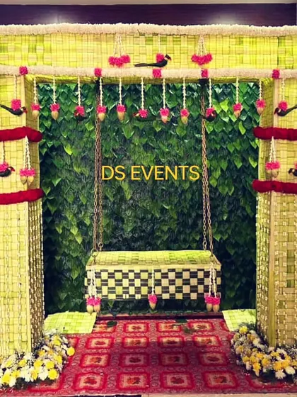 A custom-designed swing (oonjal) for a wedding ceremony or pre-wedding event. The entire structure is hand-woven from coconut leaves and decorated with flowers, creating a beautiful and eco-friendly centerpiece.