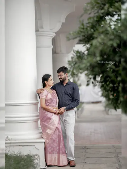 A classic, elegant portrait of a couple standing by white pillars, creating a timeless and sophisticated look.