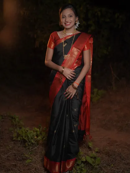 A full-length portrait showcasing the complete traditional look for Makar Sankrant. The subject's confident pose and the beautiful fall of the saree are captured in this well-lit night shot.
