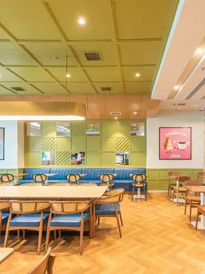 Another view of the hospital cafeteria, showcasing the use of varied seating arrangements and playful colors. The design provides a welcome break from the clinical environment, fostering connection and comfort.