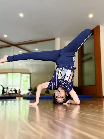 Extending into a side split from a headstand requires incredible control. This student demonstrates the connection between flexibility and balance.