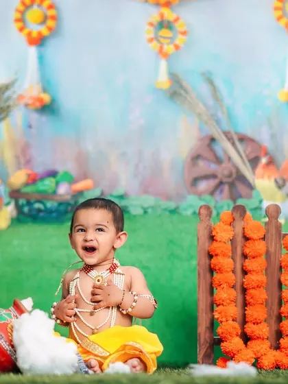 A happy little Krishna celebrates Janmashtami in our colorful and festive studio setup, complete with a pot of butter.