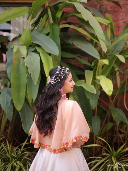 Another view of the beautiful floral headpiece and soft waves. This hairstyle is perfect for a bride who wants a unique and nature-inspired look for her pre-wedding events.