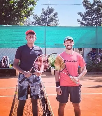 Two male competitors pose at the net after a match in the Tennis360 Open Tournament.