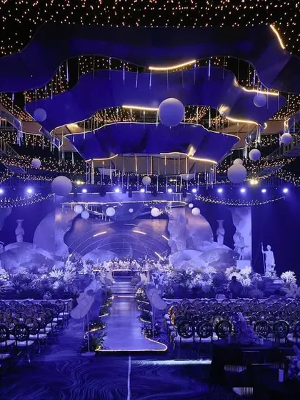 An epic, space-themed reception design. We created a massive custom chandelier and stage setup to look like a celestial scene, transforming a large convention hall into another world.