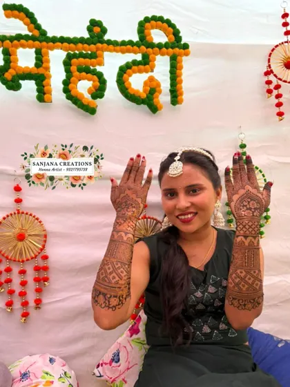 Bride Alisha at her mehndi ceremony, happily showing off her beautiful henna.