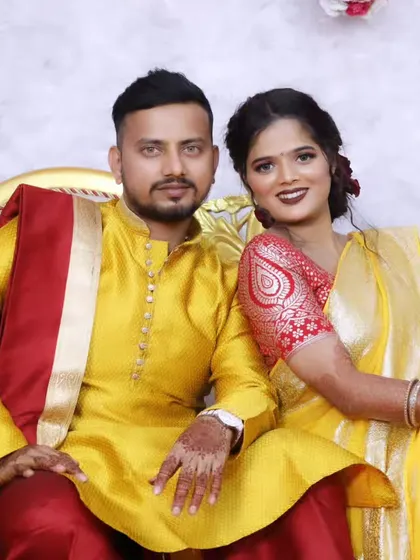 A happy couple portrait, with both bride and groom in coordinated yellow outfits for one of the wedding functions.