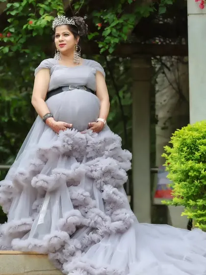 A full-length shot of a stunning grey ruffled trail gown, perfect for a glamorous and elegant maternity photoshoot.