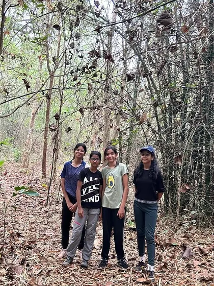 A small group of friends pauses for a photo during a forest trek at the Dandeli camp.