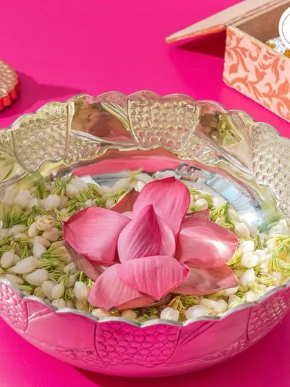 An ornate silver bowl filled with fresh jasmine and a lotus flower. Silverware like this makes for a timeless and luxurious wedding return gift.