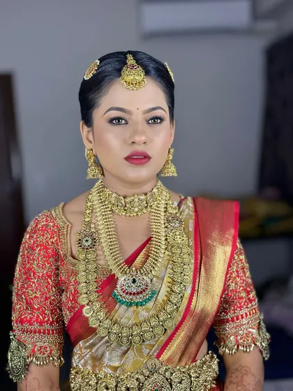 The bride looks powerful and confident. Her makeup is flawless, enhancing her strong features and complementing her regal attire.