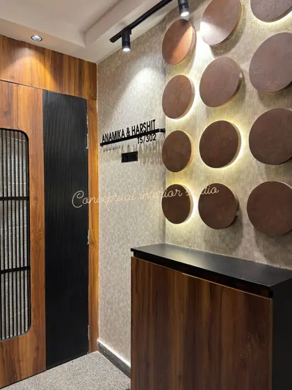 An entry design at Ace Divino. The wooden door is complemented by a backlit nameplate and a wall decorated with circular wooden accents.