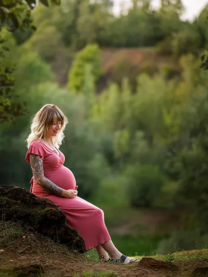A serene portrait of a mother-to-be enjoying a quiet moment in nature. The beautiful scenery provides a perfect backdrop for celebrating her pregnancy.