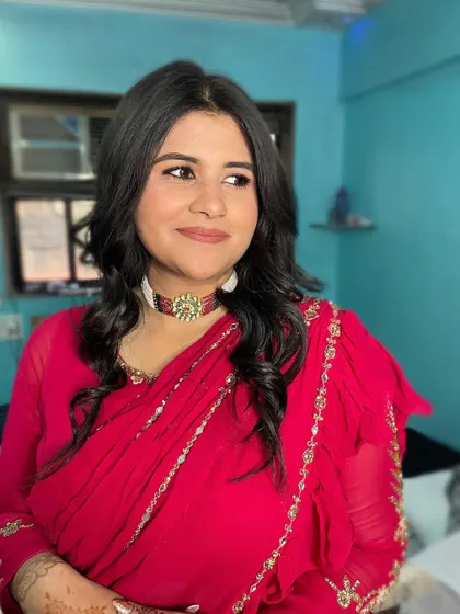 Illuminating and radiant in a vibrant red saree. The makeup is kept classic and clean, with a focus on a flawless base and defined eyes.