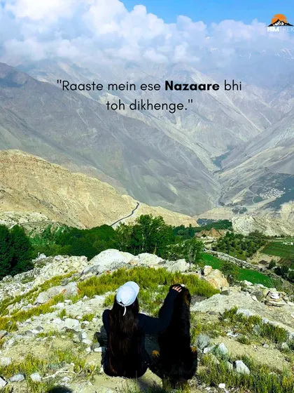 Two travelers enjoying the incredible valley views on the way to Chandratal. The text says it all: "Raaste mein ese Nazaare bhi toh dikhenge." The journey is just as beautiful as the destination.