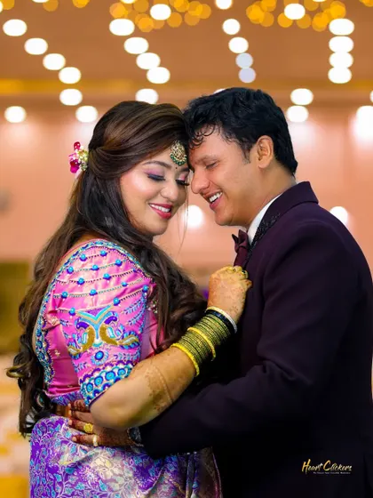 A happy, candid moment between a couple at their reception. The warm lighting and their joyful interaction make this a heartwarming shot.