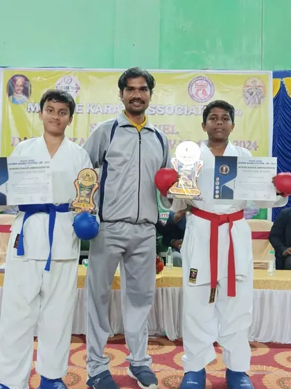 A picture with two of my students who competed and won at the Mysore Dasara Karate Championship, showcasing their medals and certificates.
