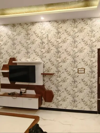 A beautiful botanical vine wallpaper serves as the perfect backdrop for a modern TV unit. The subtle pattern adds texture and elegance without overwhelming the space, seamlessly blending with the living room's contemporary design.