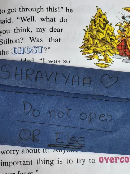 "Do not open OR Else." The playful warning on the note adds to the fun. These little interactions make our book collection feel alive and full of shared history.
