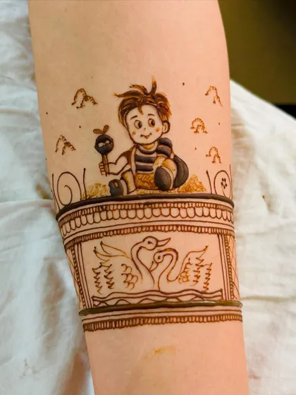 A close-up of a custom baby boy illustration on the forearm, part of a larger baby shower mehendi design.