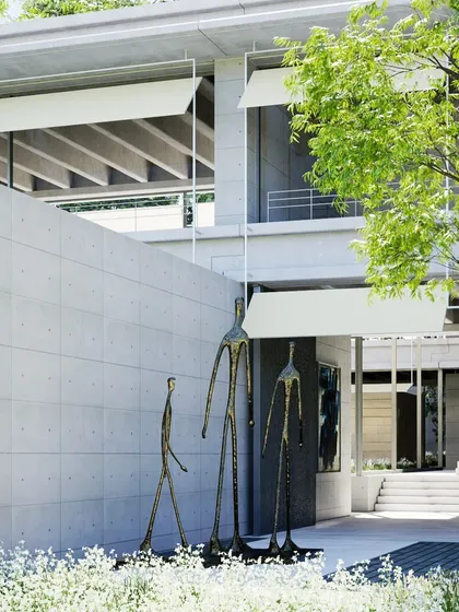 This visualization shows the entrance courtyard of the precast concrete farmhouse. The design incorporates large sculptures and uses retractable awnings to control sunlight and shade.