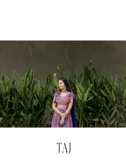 A serene and beautiful portrait of the bride against a wall of lush green leaves. The natural backdrop makes the colors of her traditional outfit pop.