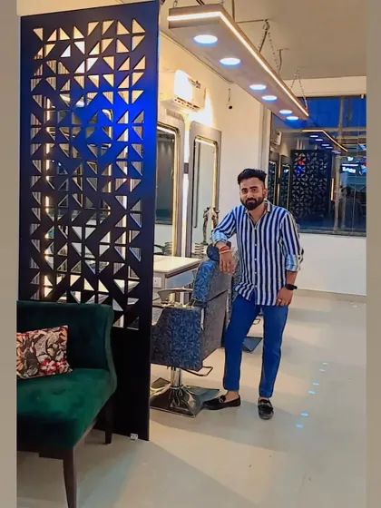 Posing in the finished Faridabad salon. The custom geometric partition behind the waiting area adds a unique design element while separating the entrance from the main styling floor.