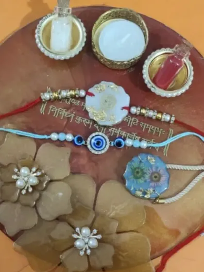 Another combination of my handmade rakhis displayed on a custom pooja thali. It shows how different rakhi designs, like the floral resin and evil eye styles, look together.