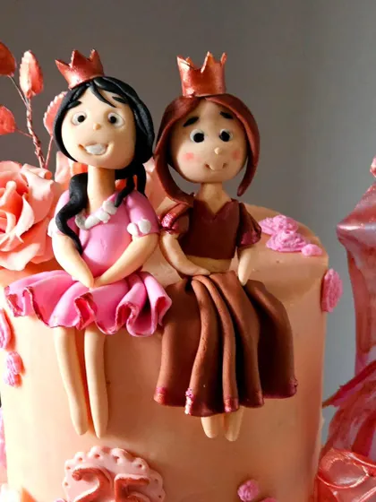 A tight shot of the two princess toppers, showcasing the detail in their dresses and their sweet expressions.