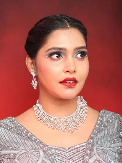 A detailed close-up of the eye makeup, featuring a blue-toned glitter and sharp liner.
