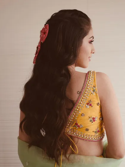 A back view of the half-updo with the red bow, showing how it adds a fun and unique element to the hairstyle.
