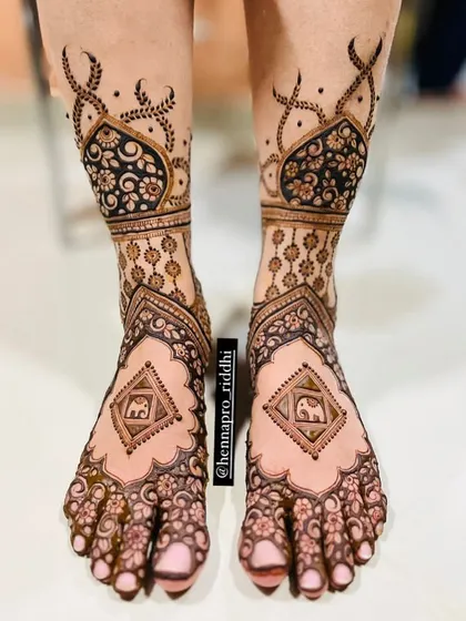 A bold and beautiful bridal foot design. The dark, filled-in patterns create a striking contrast, with elephant motifs adding a touch of traditional charm.