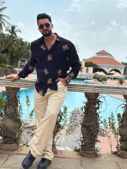 Relaxing by the pool in a stylish floral shirt. This look is perfect for a destination wedding or a resort party.