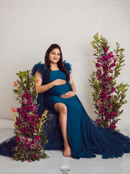A seated pose that feels both regal and relaxed. The deep teal of the gown looks incredible against the vibrant floral props.