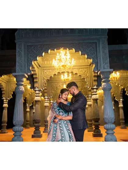 An intimate pre-wedding embrace in a grand, beautifully lit hall. The architecture and lighting create a truly romantic and epic feel.