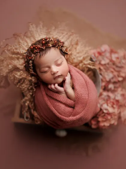 The rich, rosy tones of the wrap and flowers create a warm and romantic feel for this portrait. The tiny berry crown adds a perfect, delicate touch.